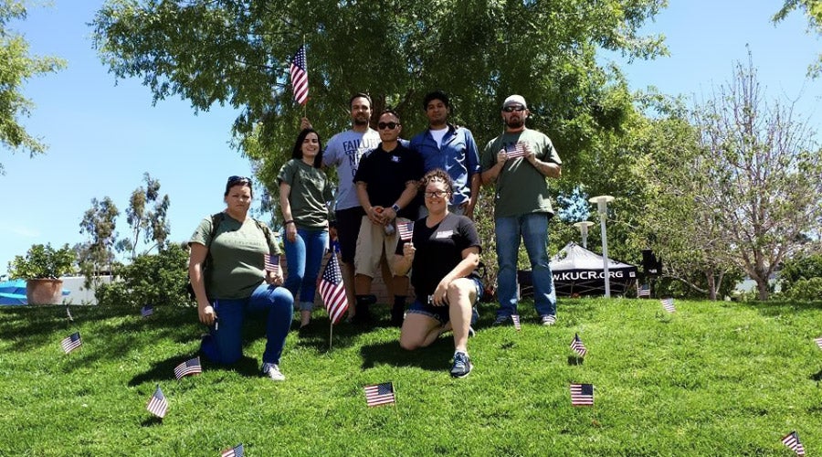 Members of the Student Veterans Organization place small flags in the UCR campus lawn in honor of Veterans Day.